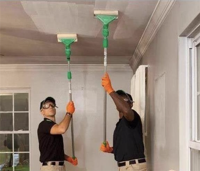 Two men cleaning soot damage